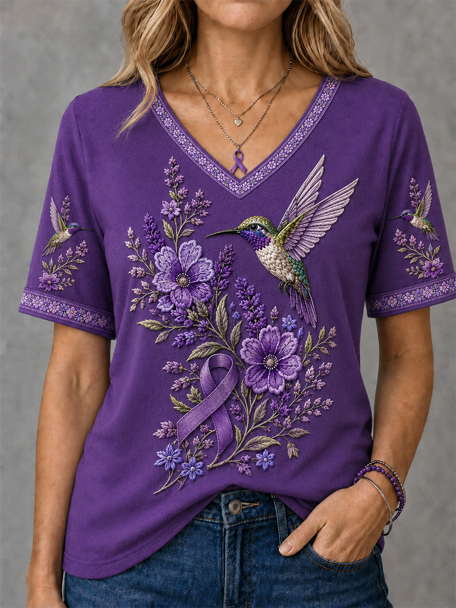 Dame-T-shirt med lilla blomster- og kolibri-print til støtte for alzheimers-håndteringen, med V‑udskæring