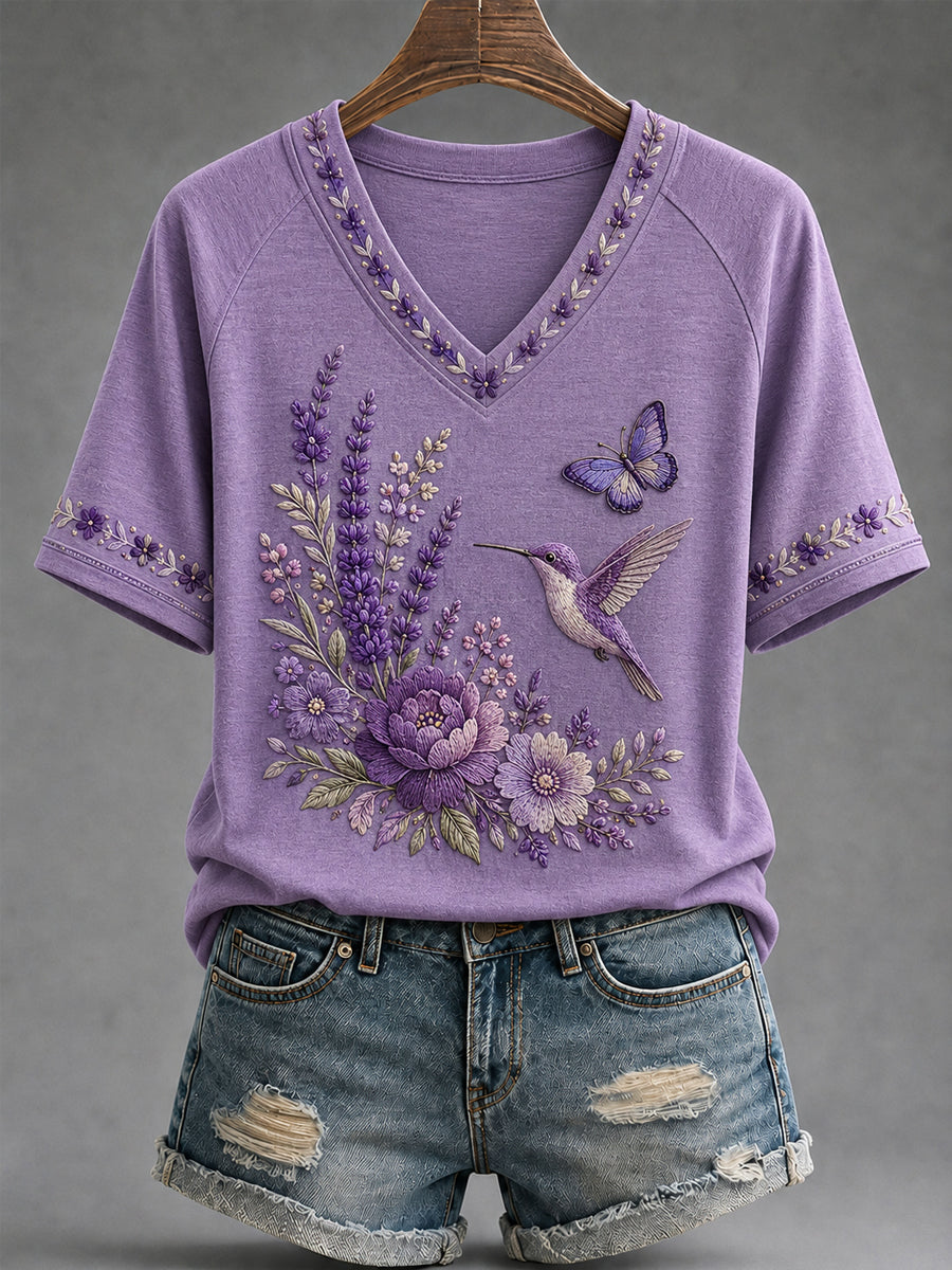 Dame-T-shirt med lilla blomster- og kolibri-print til støtte for alzheimers-håndteringen, med V‑udskæring