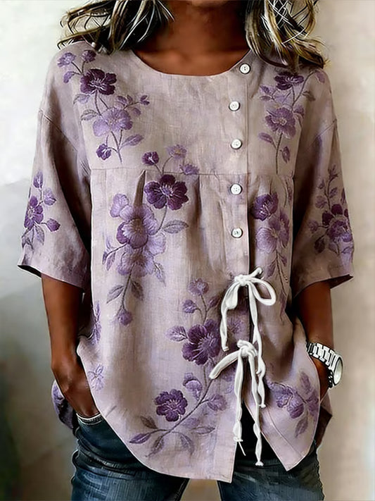 Damebluse i lilla med blomstermotiv, knapper og i et lærredsblandingssnit