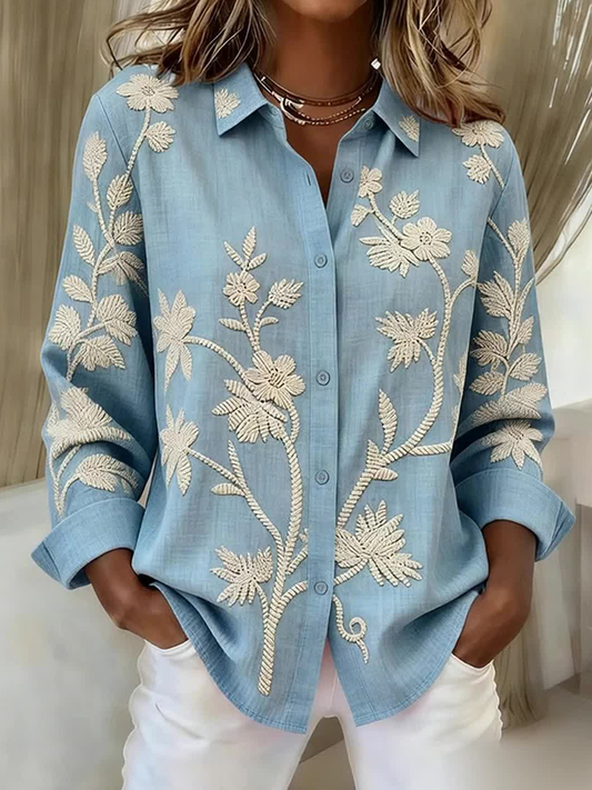 Damebluse i linnedblanding med knapper og snører, prydet med planter og blomster