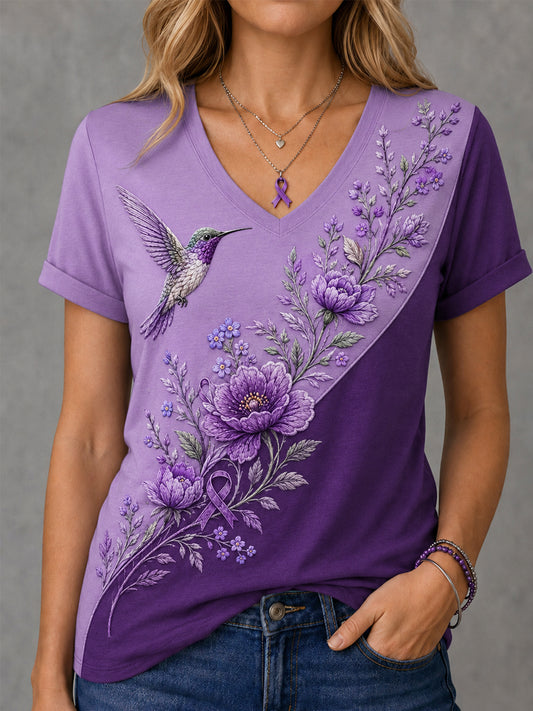 Dame-T-shirt med lilla blomster- og kolibri-print til støtte for alzheimers-håndteringen, med V‑udskæring