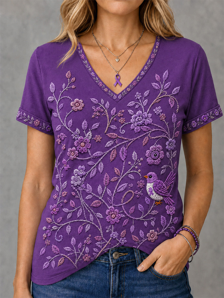 Dame-T-shirt med lilla blomster- og kolibri-print til støtte for alzheimers-håndteringen, med V‑udskæring