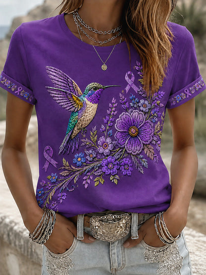 Dame-T-shirt med lilla blomster- og kolibriprint til støtte for alzheimers-ophid­sels­es­kam­pa­gnen