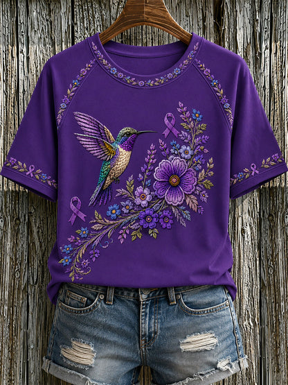 Dame-T-shirt med lilla blomster- og kolibriprint til støtte for alzheimers-ophid­sels­es­kam­pa­gnen