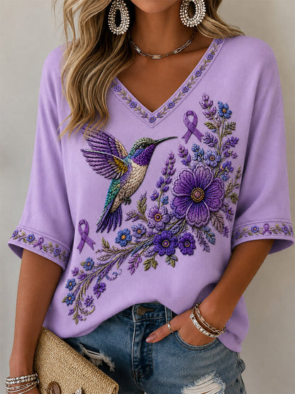 Dame-T-shirt med lilla blomster- og kolibri-print til støtte for alzheimers-håndteringen, med V‑udskæring