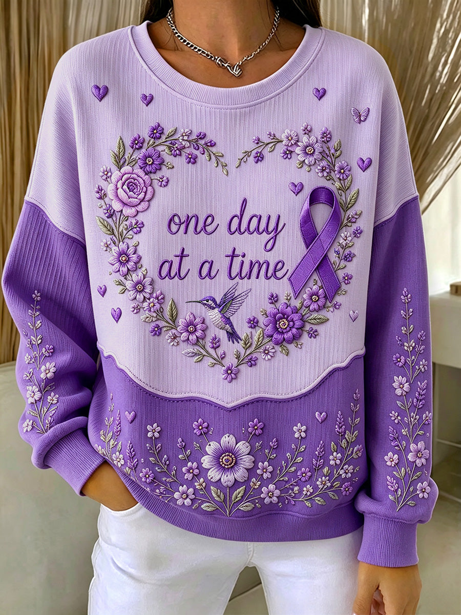Damebluse i lilla med blomstermønster og oplysning om Alzheimers, støttende print, ribbet, rund hals